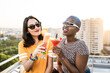 © ADDICTIVE STOCK - Multiethnic couple of cool lesbian women drinking cocktails