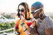 © ADDICTIVE STOCK - Multiethnic couple of cool lesbian women drinking cocktails