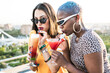 © ADDICTIVE STOCK - Multiethnic couple of cool lesbian women drinking cocktails