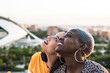 © ADDICTIVE STOCK - Stylish couple of multiracial lesbian women embracing in street