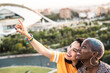 © ADDICTIVE STOCK - Stylish couple of multiracial lesbian women embracing in street