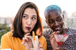 © ADDICTIVE STOCK - Multiethnic couple of cool lesbian women drinking cocktails