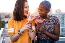Multiethnic Couple Of Cool Lesbian Women Drinking Cocktails