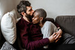 © ADDICTIVE STOCK - Young multiethnic couple resting on sofa