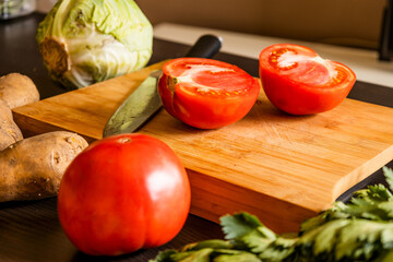 Wall Mural - cut tomato on wooden board at the kitchen table