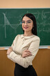 © RomanR - portrait female teacher or a student against blackboard and explain a lesson