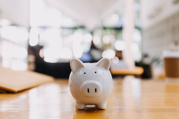 businessman hand putting coin in piggy bank. Saving money concept, business finance and investment.