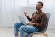 © SHOTPRIME STUDIO - Thoughtful pensive serious young man in eyewear raise hand up thinking about best solution for project sitting in chair at home. Remote Job Distant Work Communication Modern Profession concept