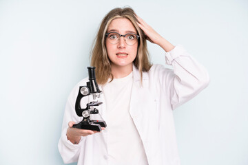 Wall Mural - caucasian pretty woman looking serious showing open palm making stop gesture. science student with a microscope