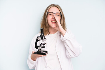 Wall Mural - caucasian pretty woman with cheerful and rebellious attitude, joking and sticking tongue out. science student with a microscope