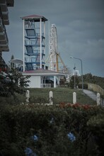 Vertical Shot Of A Part Of An Amusement Park With A Ferris Wheel