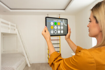 young woman holding digital tablet with black empty screen for mockup template, standing at modern kitchen. Technology, Template, Automation, Smart Home Concept.
