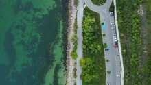 Drone Shot Of The Concrete Wave Breakers In Turquoise Water And Seaside Roads And Gardens
