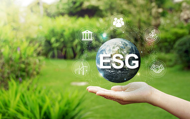 Wall Mural - ESG icon concept circulating in hands for society, environment and governance. ESG. in sustainable business on networked connections natural green background.                         
