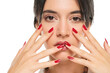 woman shows her red nail polish on a white studio background