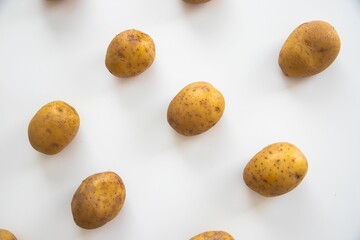 Wall Mural - Top view of raw potatoes put separately on a white surface