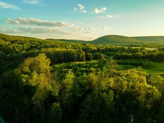 Sticker - Drone landscape over lush farm fields and green dense forest under sunset sky in Pennsylvania