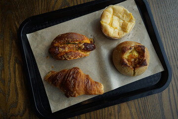 Various French pastry in black tray on wooden table