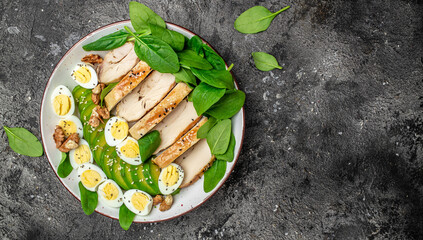 Poster - salad avocado, grilled chicken fillet, quail egg, spinach, walnut on a dark background. keto diet. Healthy fats, clean eating for weight loss, Long banner format. top view