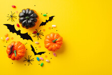 Halloween Concept. Top View Photo Of Pumpkins Candies Bat Silhouettes Centipede Spiders And Confetti On Isolated Yellow Background