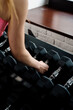 Gym. Female hand takes black dumbbells from the rack
