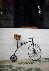 Wall Mural - Decorative bycicle in front of a coffee shop and a glass wall in the back