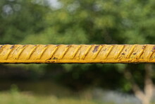 One Long Iron Yellow Bar Rebar Outdoors On A Green Background