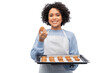 cooking, culinary and people concept - happy smiling woman in apron holding baking tray with oatmeal cookies over white background