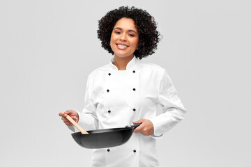 Wall Mural - food cooking, culinary and people concept - happy smiling female chef with frying pan over grey background