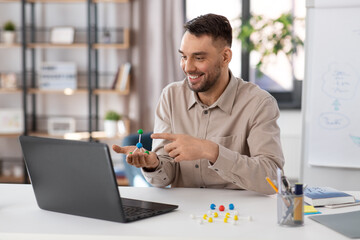 Canvas Print - distance education, school and remote job concept - happy smiling male chemistry teacher with laptop computer and molecular model having online class at home office