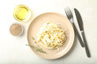 Fresh white carrot salad served with oil and spices on light table, flat lay