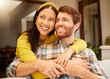 © N Felix/peopleimages.com - Happy and excited couple hugging thinking of future relaxing and sitting on a couch at home. Relaxed diverse interracial lovers smiling and enjoying quality time together and having fun in the house