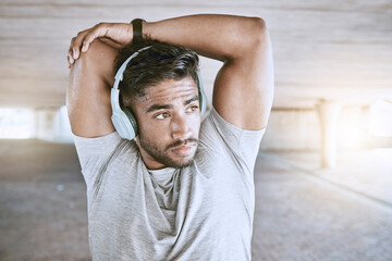 Poster - Fitness man training with headphones stretching, listening to music or a motivation podcast with lens flare in urban city. Sports person with an online audio for his warmup morning workout exercise