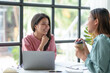 © amnaj - Two young Asian business women discuss work and jointly plan sales and marketing strategy to the company in making new product.