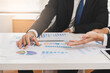© KMPZZZ - Business people meeting. Businessman, partnership planning strategy of project, brainstorming with colleague, using device on touchpad, tablet analyzing data, discussing document, paperwork at office.