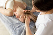 © Татьяна Волкова - Top view of young masseuse therapist massaging head of young woman with closed eyes lying on couch. Health, relaxation.