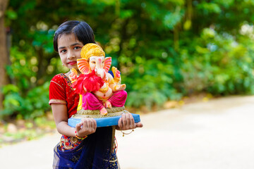 Wall Mural - Cute indian little girl celebrating lord ganesha festival.