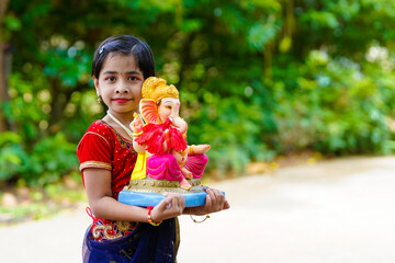 Wall Mural - Cute indian little girl celebrating lord ganesha festival.