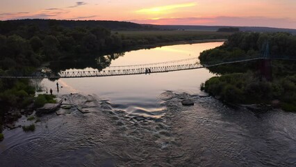 Wall Mural - Eine Hängebrücke über einen Fluss in Russland bei Sonnenuntergang.