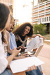 © Look! - Creative young interracial students with gadgets are discussing project during meeting on street. Guy and girls exchange ideas. Concept lifestyle, education