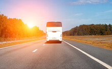A Modern Comfortable Passenger Bus Rides Along The Highway Against The Backdrop Of The Sun In Summer. The Concept Of European Tours By Bus. Copy Space For Text
