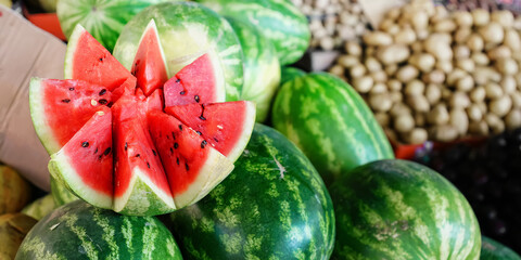 Wall Mural - Cutting fresh water melon with red succelent pulp is selling at city market closeup view