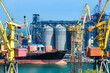 Leinwandbild Motiv industrial infrastructure of seaport, sea, cranes and dry cargo ship, grain silo, bulk carrier vessel and grain storage elevators, concept of sea cargo transportation