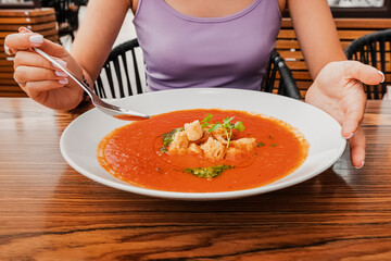 Wall Mural - Woman eating delicious tomato soup in cafe or restaurant. Vegetarian cuisine and healthy vegetable diet. Dinner and meal with organic products