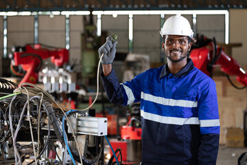 African electrician engineer or worker checking electric cable in robot factory