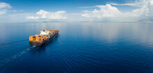 Panoramic Aerial View Of A Industrial Cargo Container Ship Traveling Over Calm, Open Sea With Copy Space