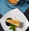 slice of cheesecake on a plate with cup of coffee