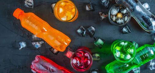 Top view  lot of bottles Soft drinks in colorful and flavorful  on the table, Glasses with sweet drinks with ice cubes