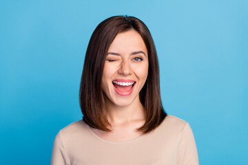 Wall Mural - Portrait of overjoyed satisfied lady eye wink beaming smile isolated on blue color background