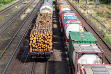 Above View Of Railway Sorting Station With Many Lines Directions In Germany. Railroad Car Wooden Timber Logs And Gas Tanks Logistics. Raw Wood Heating Material Transportation. Freight Cargo Transport